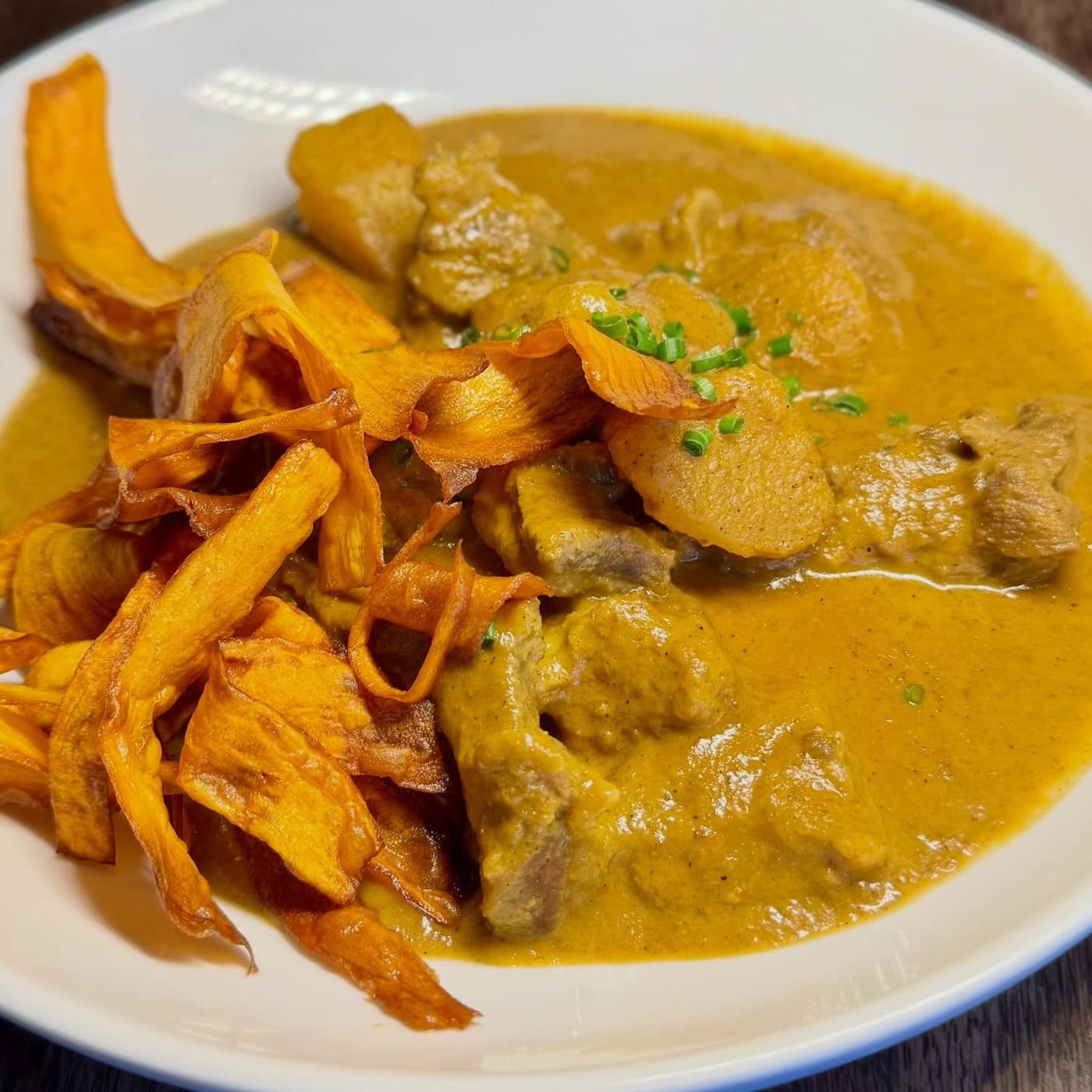 Kerala style lamb curry topped with sweet potato crisps